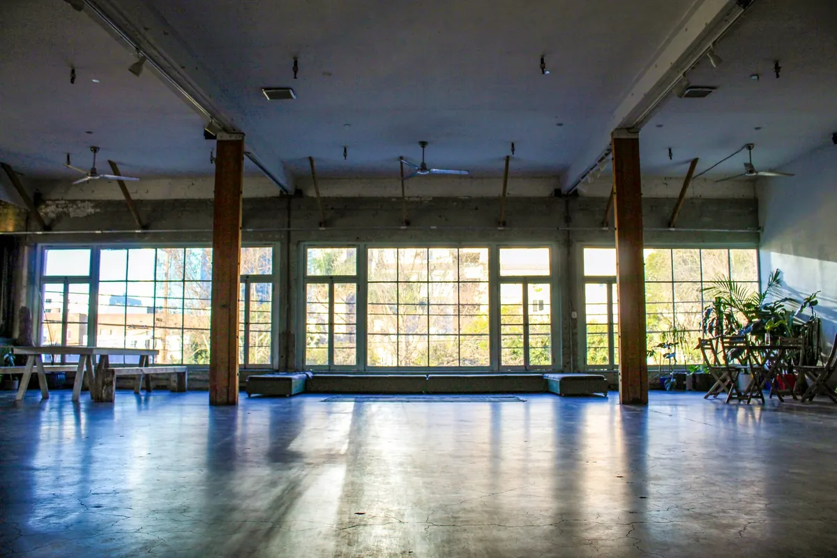 Studio A empty in the morning, light across the concrete floor